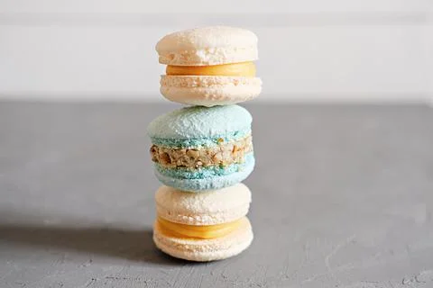 Stack of french macaron cookies on a grey table. pastel yellow and turquoise  Stock Photos