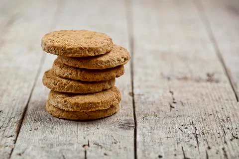 Stack of fresh baked oat cookies on rustic wooden table background. Stock Photos