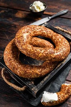 Stack of fresh baked Turkish simit bagel with kaymak. Wooden background. Top Stock Photos