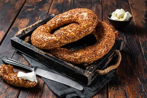 Stack of fresh baked Turkish simit bagel with kaymak. Wooden background. Top Stock Photos