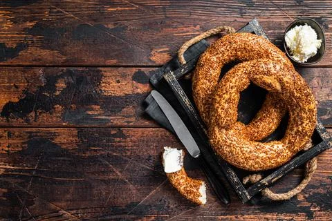 Stack of fresh baked Turkish simit bagel with kaymak. Wooden background. Top Stock Photos