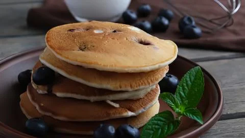 Stack of fresh blueberry pancakes with syrup and mint leaves Stock Photos