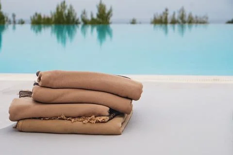 Stack of fresh clean pool towels near the swimming pool. Stock Photos