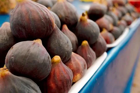 Stack of fresh figs is arranged at  market. dark and purple skins shine under Stock Photos