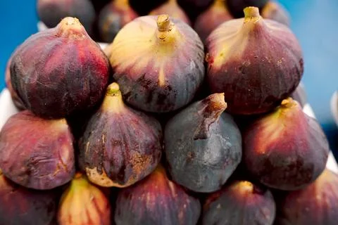 Stack of fresh figs is arranged at  market. dark and purple skins shine under Foto stock