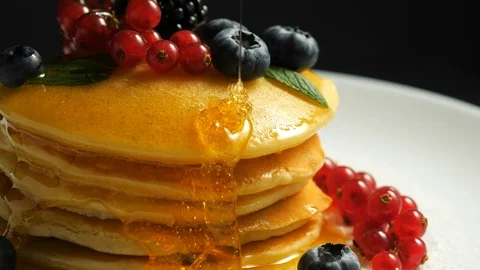 Stack of fresh fluffy pancakes decorated on top with forest berries rotating on Stock Footage 100094380