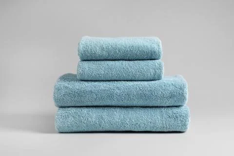 Stack of fresh fluffy towels on grey background 스톡 사진