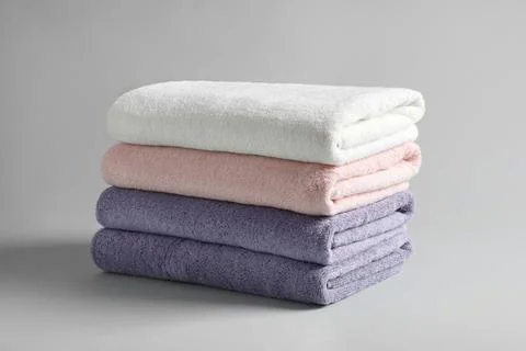 Stack of fresh fluffy towels on grey background Stock Photos