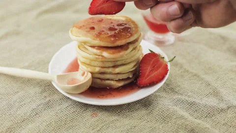 A stack of fresh fragrant hot pancakes on a white plate 動画素材 147171924