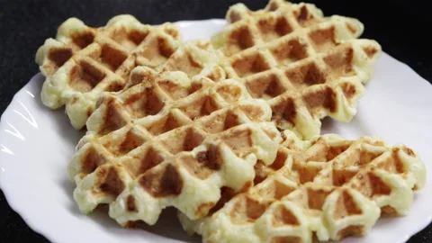 Stack of fresh homemade Belgian waffles served on a minimal white plate Stock Footage 336902547