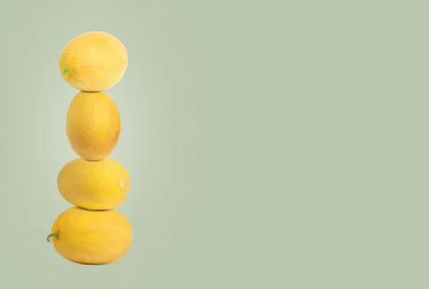 Stack of fresh melons on pale dusty green background. Space for text 스톡 사진