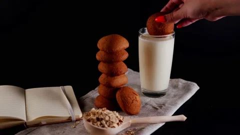 Stack of fresh oatmeal cookies with milk in glass, raw oat flakes in large Stock Footage 208943683