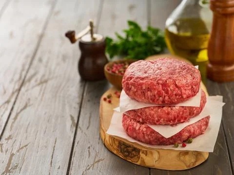 Stack of fresh raw burger patty or ground beef meat burger steak cutlets on d Foto stock