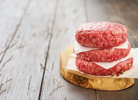 Stack of fresh raw burger patty or ground beef meat burger steak cutlets on d Foto stock