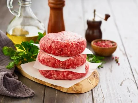 Stack of fresh raw burger patty or ground beef meat burger steak cutlets on d Foto stock