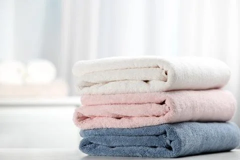 Stack of fresh soft towels on table Stock Photos