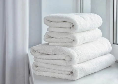 Stack of fresh soft towels on windowsill Foto stock