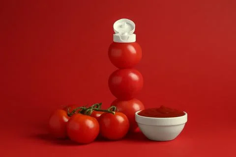 Stack of fresh tomatoes with plastic cap as bottle and ketchup in bowl on r.. 스톡 사진