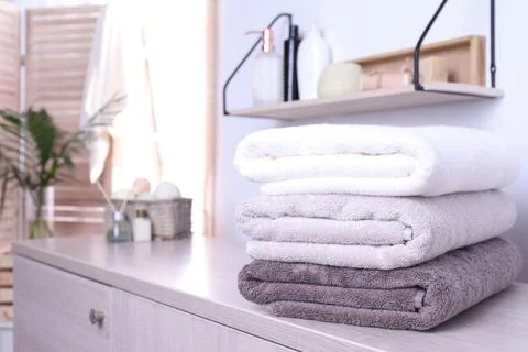 Stack of fresh towels on cabinet in bathroom. Space for text Stockfoto's