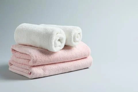 Stack of fresh towels on light background. Space for text Foto stock