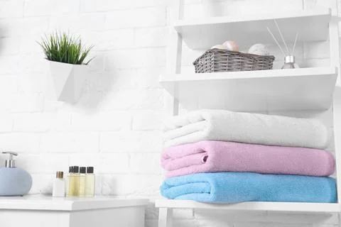Stack of fresh towels on shelf in bathroom. Space for text 스톡 사진