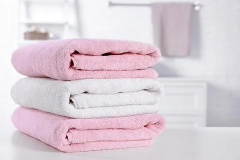 Stack of fresh towels on table in bathroom. Space for text Foto stock