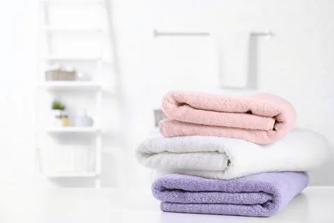 Stack of fresh towels on table in bathroom. Space for text 库存照片