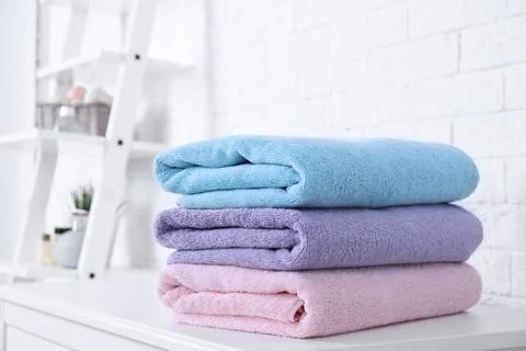 Stack of fresh towels on table in bathroom. Space for text 스톡 사진