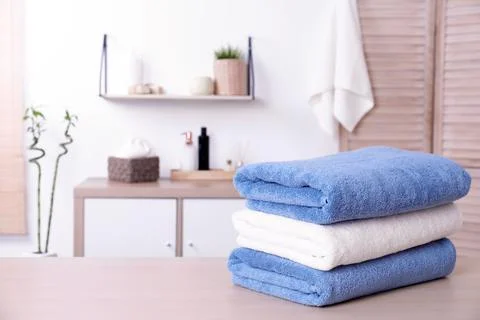 Stack of fresh towels on table in bathroom. Space for text Foto stock