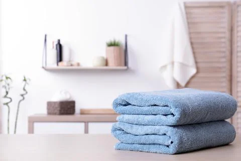 Stack of fresh towels on table in bathroom. Space for text 스톡 사진