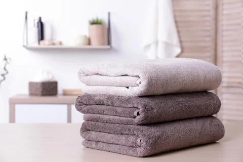 Stack of fresh towels on table in bathroom. Space for text 写真素材