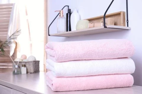Stack of fresh towels on table in bathroom. Space for text Foto stock