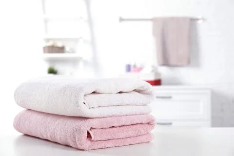 Stack of fresh towels on table in bathroom. Space for text 스톡 사진