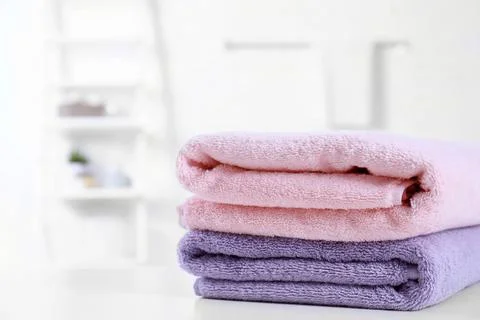 Stack of fresh towels on table in bathroom. Space for text 스톡 사진