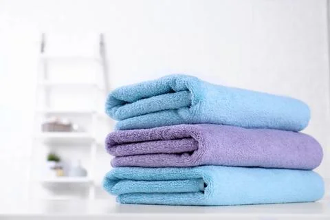 Stack of fresh towels on table in bathroom. Space for text 스톡 사진