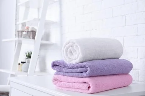 Stack of fresh towels on table in bathroom. Space for text Foto stock