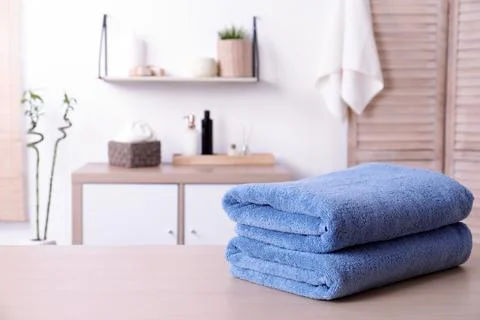 Stack of fresh towels on table in bathroom. Space for text 스톡 사진