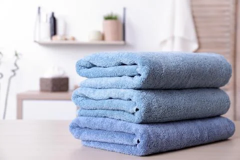 Stack of fresh towels on table in bathroom. Space for text 스톡 사진