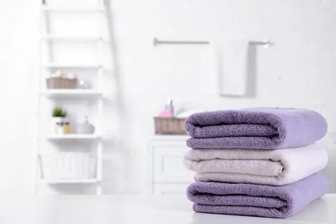 Stack of fresh towels on table in bathroom. Space for text Foto stock