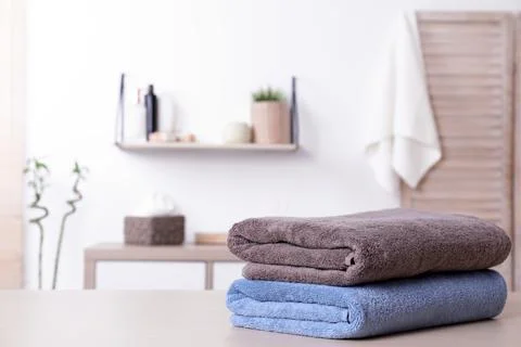 Stack of fresh towels on table in bathroom. Space for text Stockfoto's