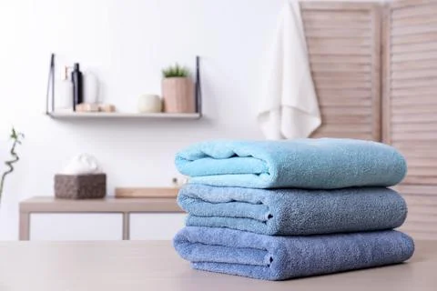 Stack of fresh towels on table in bathroom. Space for text 스톡 사진