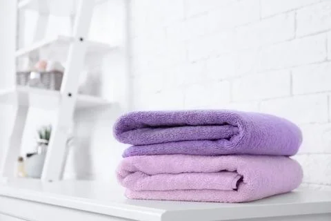 Stack of fresh towels on table in bathroom. Space for text 스톡 사진