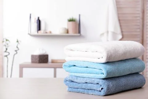 Stack of fresh towels on table in bathroom. Space for text Foto stock