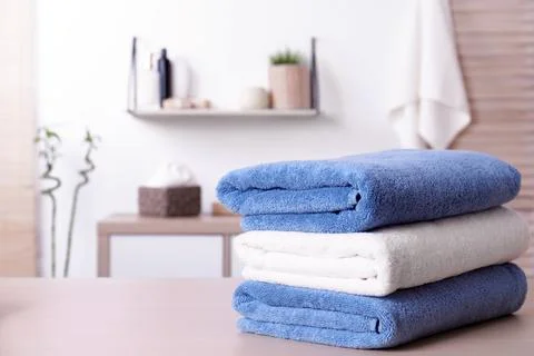Stack of fresh towels on table in bathroom. Space for text Stockfoto's