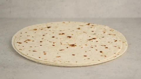 Stack of fresh wheat tortillas rotating on neutral background for food comm.. Video stock 332625013