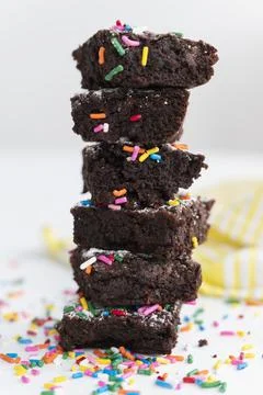 Stack of freshly baked brownies covered with colorful sprinkles 写真素材