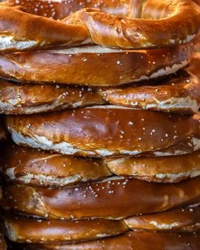 Stack of freshly baked pretzels on a bakery stall at a food market Stock Photos