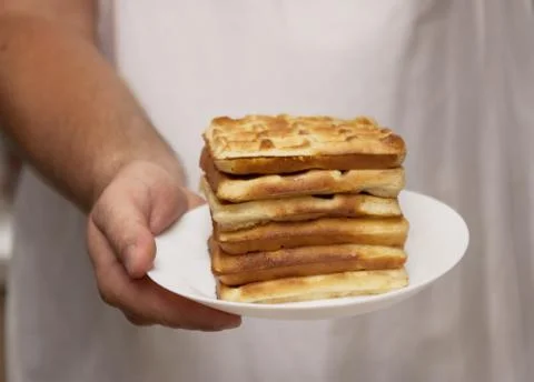 A stack of freshly baked wafers in the chef's hands for men, close-up, retro  Stock Photos