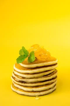 Stack of freshly home made pancakes isolated over bright yellow background Foto stock