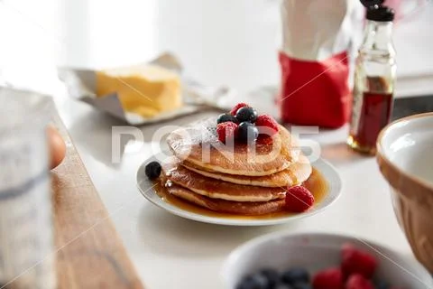 Stack Of Freshly Made Pancakes Or Crepes With Maple Syrup And Berries On Table Stock Photos